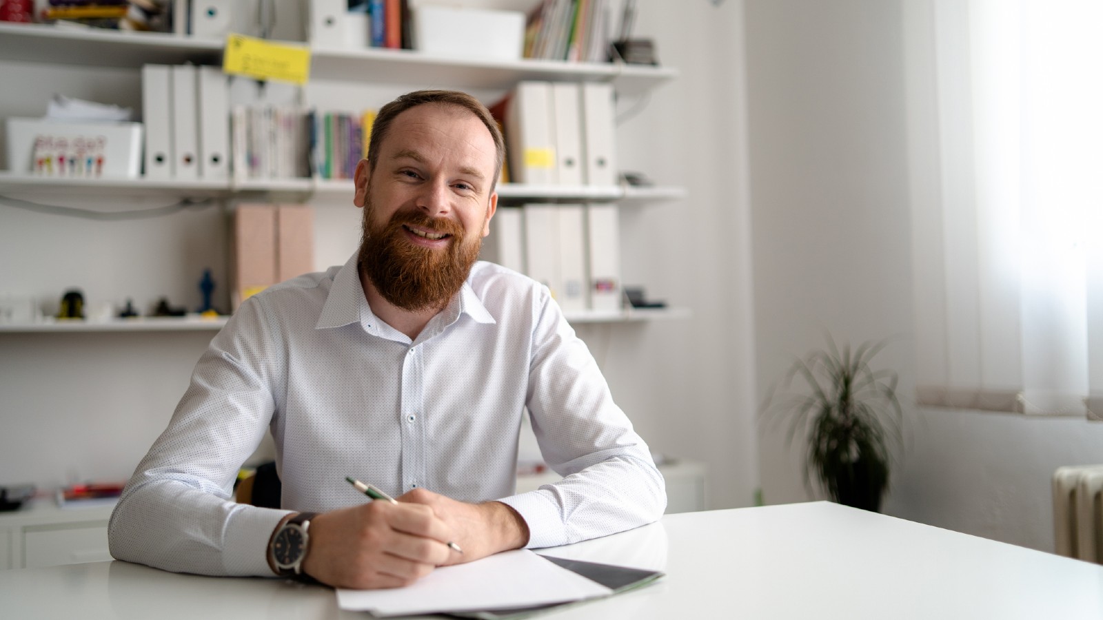 Man in business attire sitting in office doing paperwork